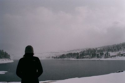 Silhouette of woman standing against cloudy sky