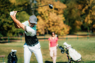 Teeing off. golf couple playing golf, enjoing a beautiful sunny day on the golf course