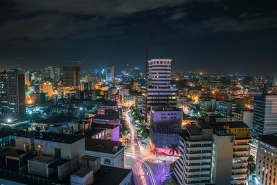 Illuminated cityscape against sky at night