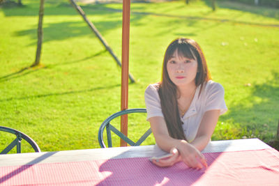 Portrait of young woman sitting on field