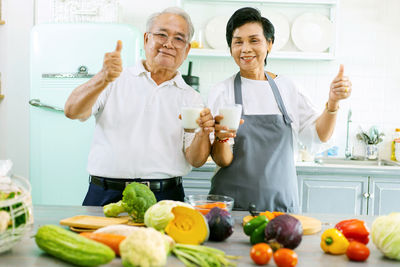 Man and woman standing by fruits