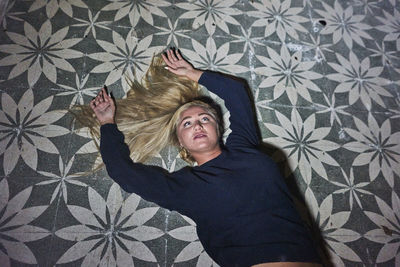 High angle view of young woman lying on floor