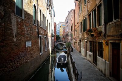 Alley amidst street in city against sky