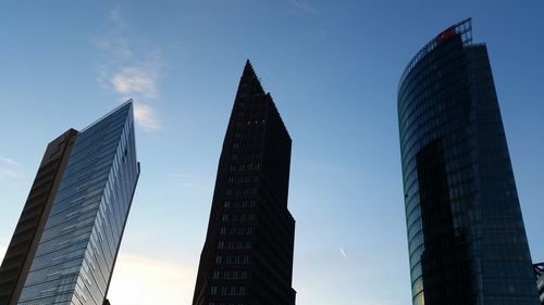 Low angle view of skyscrapers against blue sky