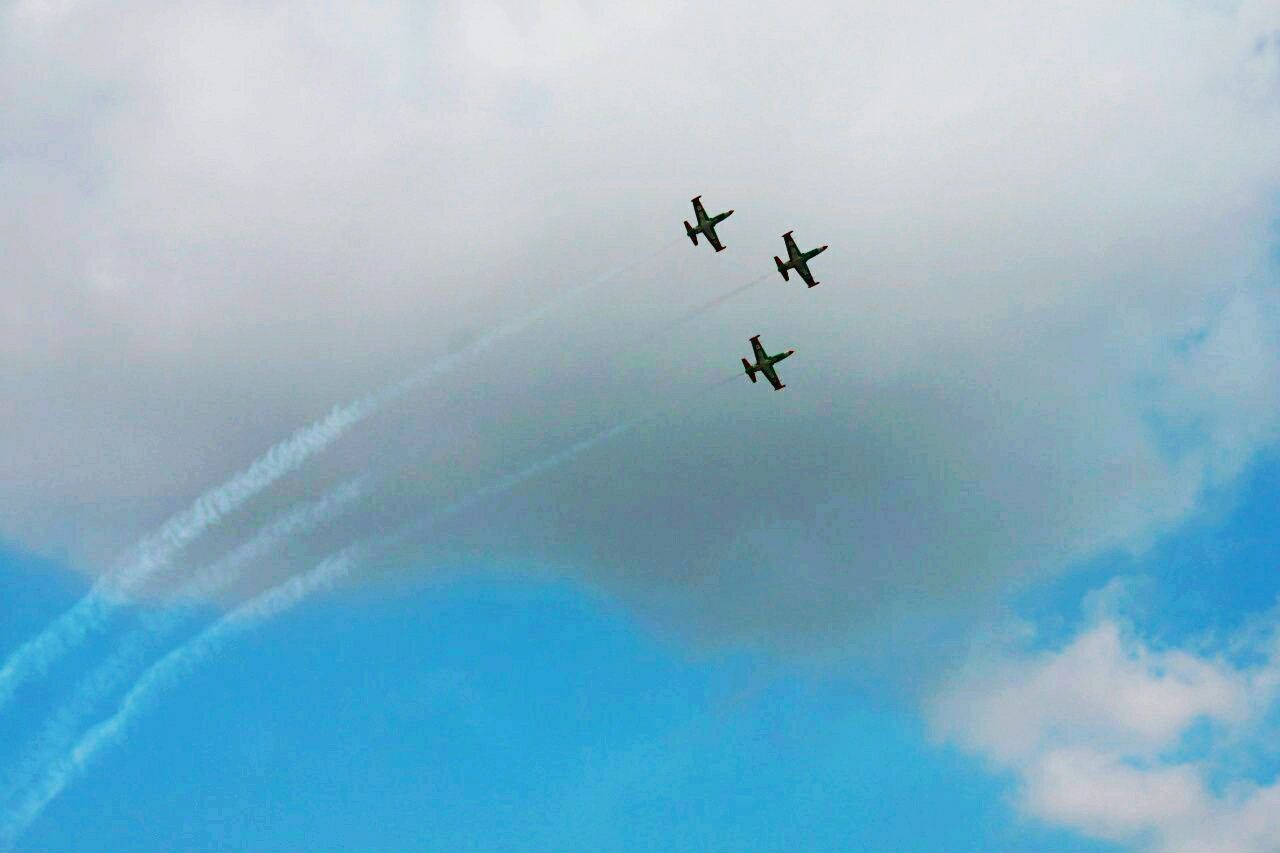 flying, low angle view, mid-air, sky, cloud - sky, nature, blue, day, adventure, beauty in nature, outdoors, scenics, cloudy, cloud, tranquility, tranquil scene, weather