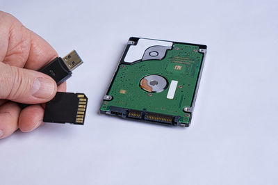 High angle view of person holding camera over white background