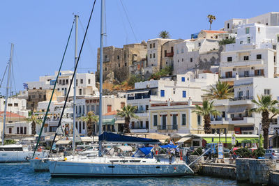 Boats moored at harbor against buildings in city