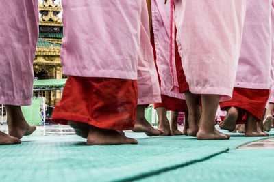 Low section of people wearing traditional clothing walking outdoors