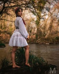 Full length of woman standing by water