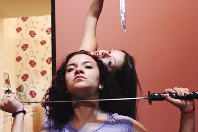 Portrait of friends holding swords while practicing for theatrical performance