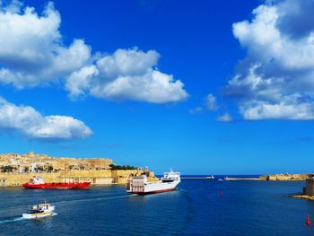 Boats in sea against blue sky