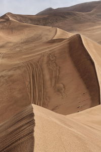 1177 tire tracks on the slope of a megadune-sumu barun jaran lake's east shore-badain jaran desert.