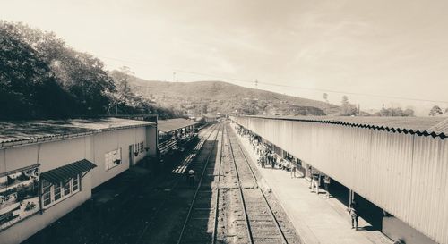 Railroad tracks by bridge against sky
