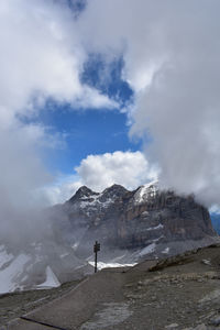 Man standing on rock against sky