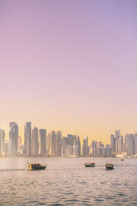 Scenic view of sea by buildings in city against sky