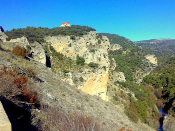 Scenic view of rocky mountains against blue sky