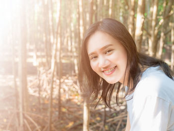 Smiling asian women taking pictures while going on vacation. in the forest 