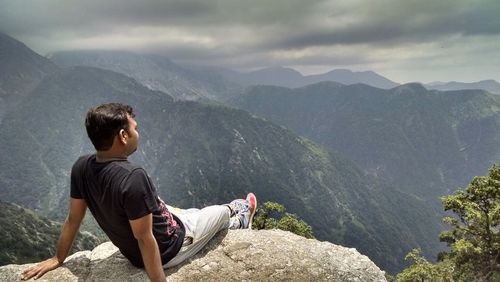 Rear view of man looking at mountain landscape