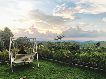 Rear view of woman sitting on swing