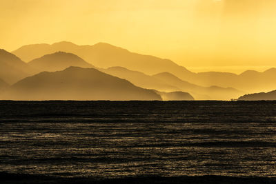 Scenic view of silhouette mountains against sky during sunset