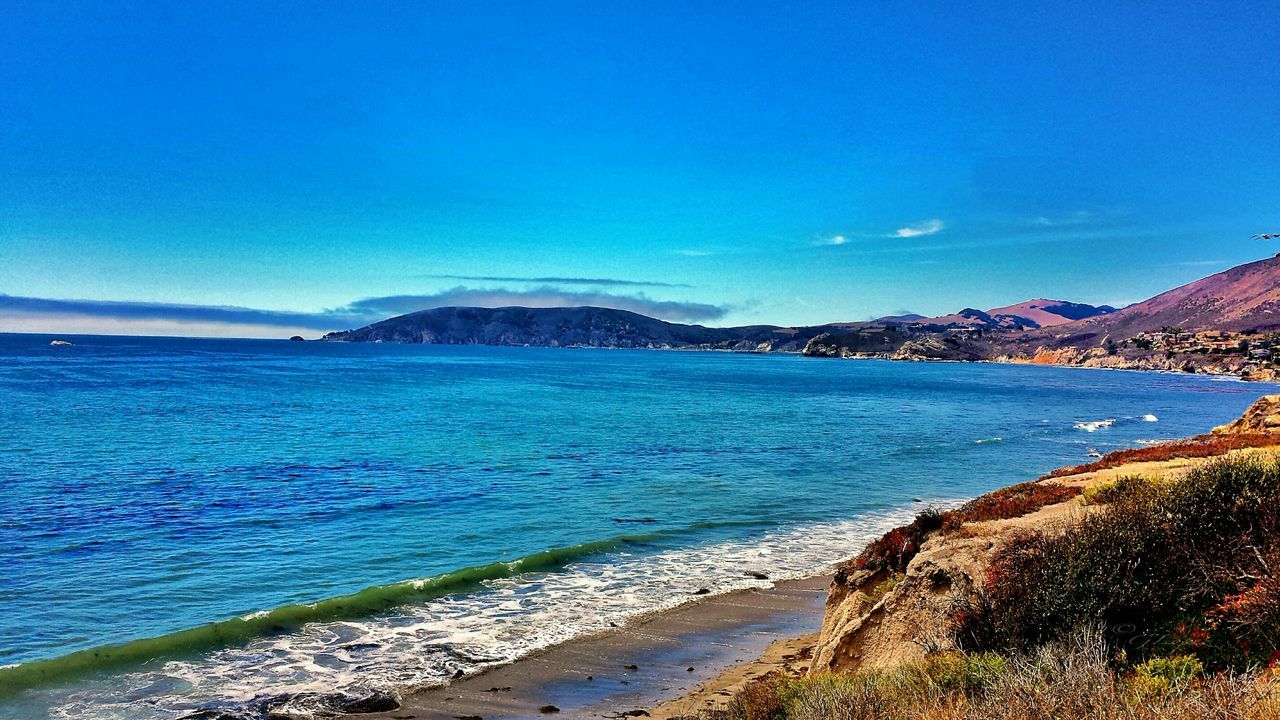 sea, water, blue, mountain, scenics, beauty in nature, tranquil scene, tranquility, coastline, beach, nature, sky, idyllic, mountain range, shore, clear sky, day, copy space, horizon over water, high angle view