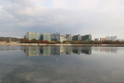 Reflection of buildings in lake against sky