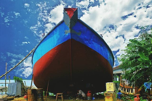 sky, built structure, architecture, cloud - sky, transportation, blue, building exterior, nautical vessel, cloud, mode of transport, day, flag, multi colored, outdoors, incidental people, travel, boat, low angle view, travel destinations, tourism