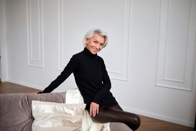 Stylish mature woman on sofa in living room