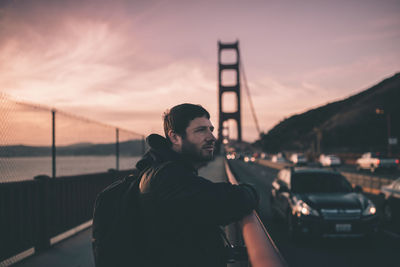 Side view of man on golden gate bridge during sunset