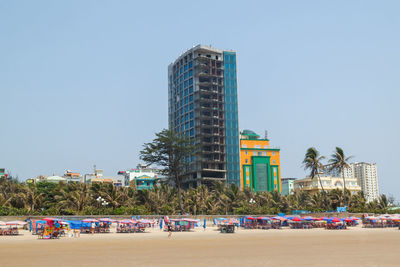 Vung tau, vietnam. beachfront buildings and empty chairs on sandy shore.