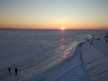 Scenic view of beach against clear sky during sunset