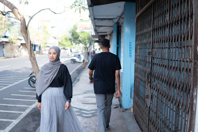 Rear view of people walking on street