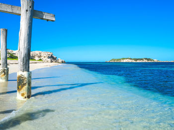 Scenic view of beach against clear blue sky