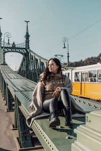 Lifestyle photo of attractive woman sitting on liberty bridge in budapest, hungary