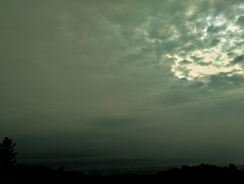 Scenic view of storm clouds over silhouette landscape