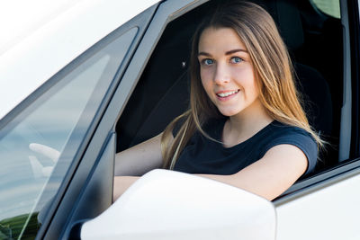 Portrait of smiling woman sitting in car