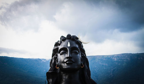 Low angle view of shiva statue against sky