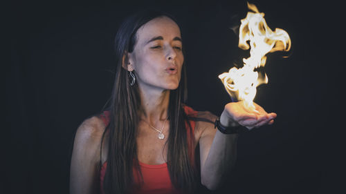 Beautiful woman holding a flame of fire in her hand
