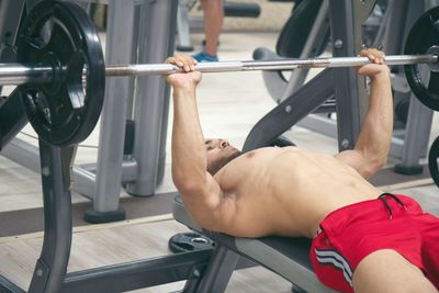 Shirtless man exercising at gym