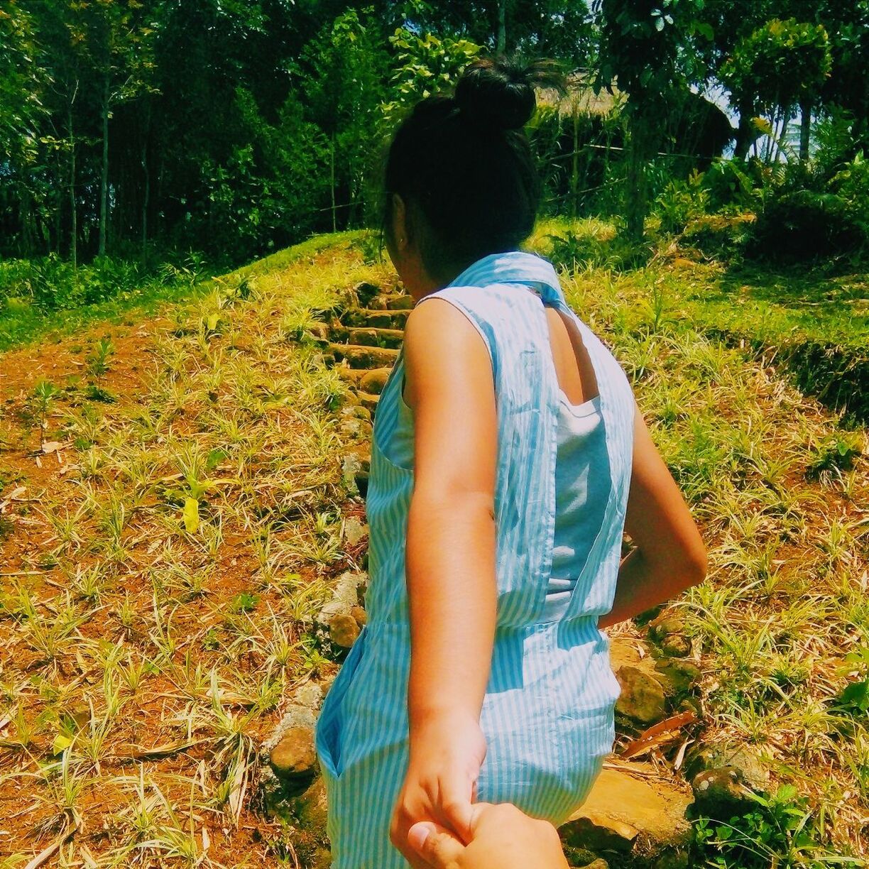 REAR VIEW OF WOMAN STANDING IN GRASS