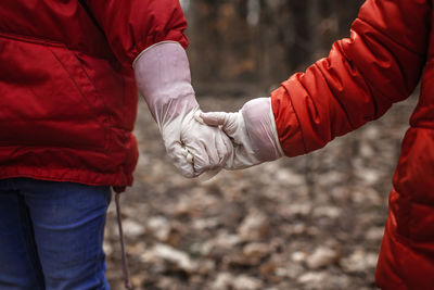 Midsection of people holding hands while walking outdoors