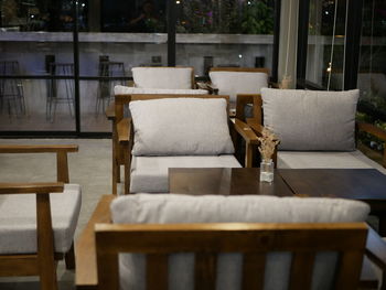 Empty chairs and table in cafe against building