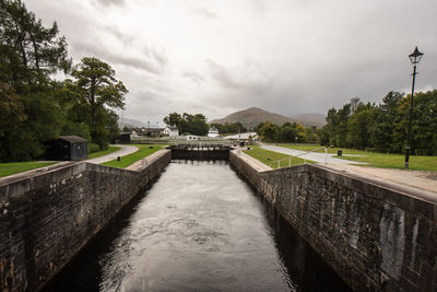 Bridge over canal against sky