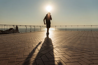 Silhouette man standing against sky during sunset