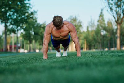 Man looking away while sitting on grass