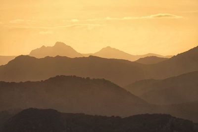 Scenic view of silhouette mountains against sky during sunset