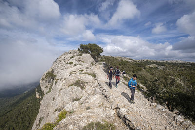 People on mountain against sky