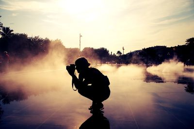 Side view of a silhouette female photographer