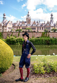 Full length portrait of man standing against building