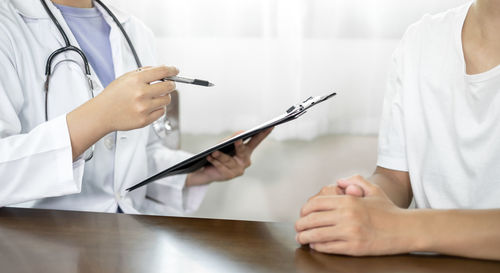 Midsection of doctor examining patient at clinic